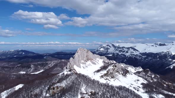 Aerial drone view of difficult access mountain peak for climbers during a winter sunny day