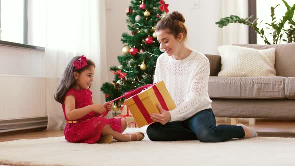 Mother and Daughter with Christmas Gift at Home 