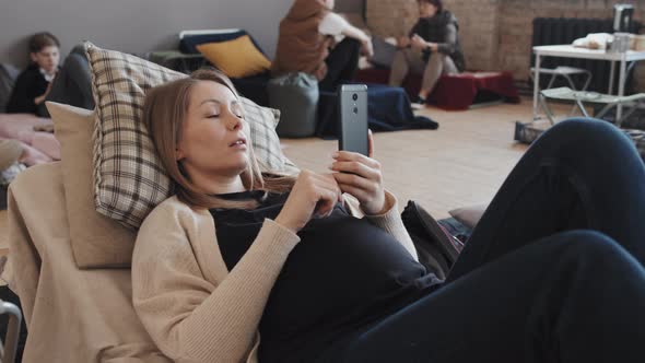 Pregnant Woman Using Smartphone in Shelter