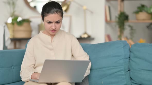Indian Woman with Laptop Reacting to Failure on Sofa