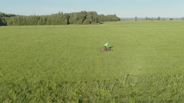 Man in Green Helmet Throwing and Catching a Boomerang Rides Fast Pedal on Orange Enduro Electro Full