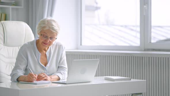 Senior lady manager with grey haircut in glasses