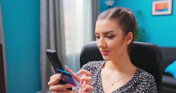 Female Hands Using a Credit Card and a Smartphone for Online Banking While Sitting a