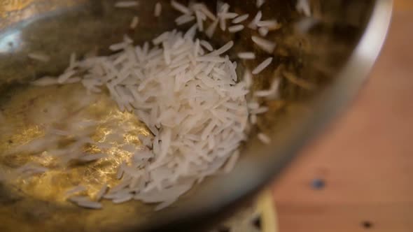 Dry Basmati Rice Fall in Wood Gold Metal Bowl on Table From Hands Woman Slow Motion Close Up Macro