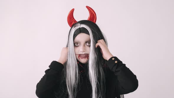 Kid in Scary Evil Costume Grimacing on White Background