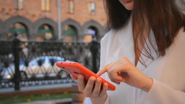 A Girl Uses the Phone in the City