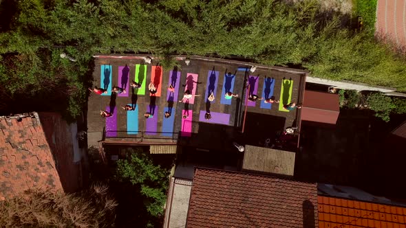 Aerial view of the top of a roof with a group of people doing yoga.