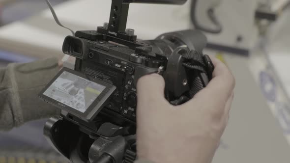 Close-up of a DSLR Camera in the Hands of a Cameraman Photographer While Shooting a Video Photo