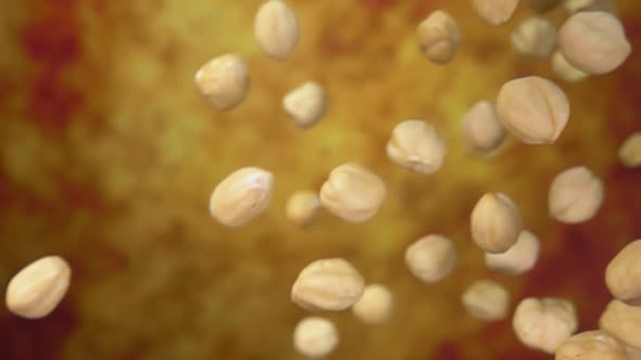 Closeup of Peeled Hazelnuts Falling Diagonally on a Yellow Ochre Background