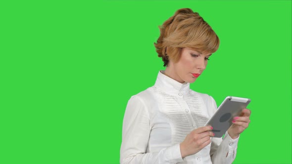 Young Woman Using a Tablet on a Green Screen, Chroma Key