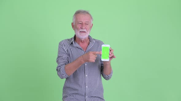 Happy Senior Bearded Man Showing Phone and Giving Thumbs Up