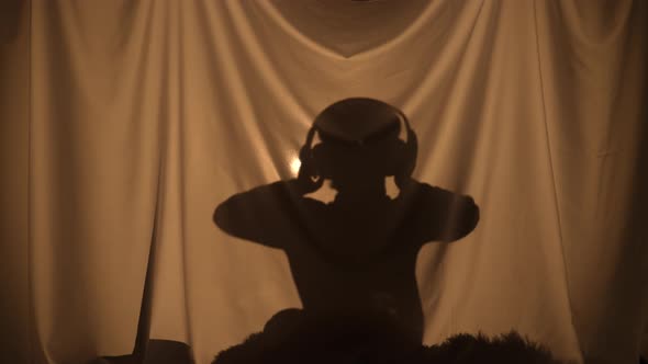 Silhouette of Little Boy Enjoying Music with Big Headphones