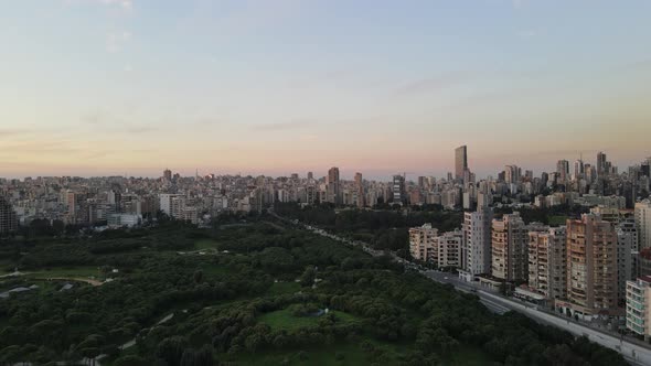 Drone shot - Flyover Beirut during sunset time showing Horsh Beirut (Beirut Park)
