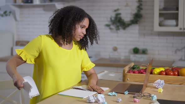 Overburdened African American Young Woman Tearing Page and Crumpling Paper