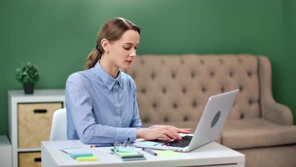 Focused Business Woman Working on Laptop at Home Office