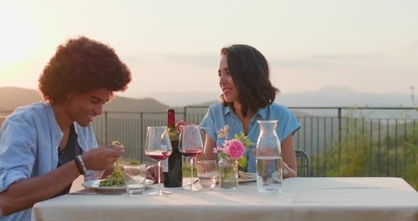 Couple in Love Happy Talking and Eating During a Romantic Gourmet Dinner Outdoor at sunset