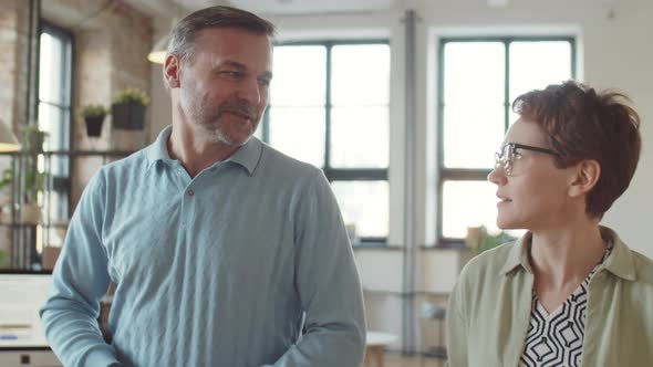 Colleagues Speaking while Walking in Office