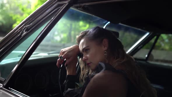 Sorrowful Woman Is Leaning on Steering Wheel in Auto Is Suffering From Loneliness and Break Up