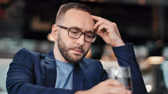 Upset Businessman with Painful Face Drinking Alcohol at Pub