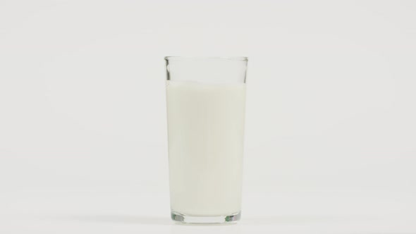 Hand taking away a glass of milk