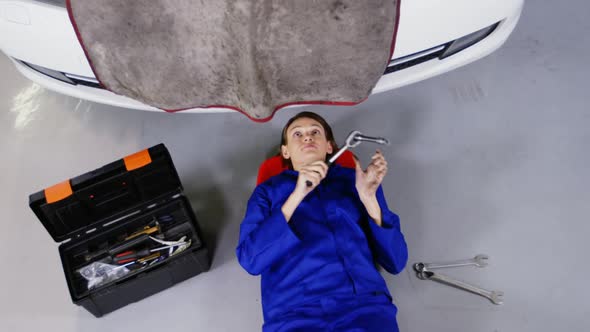 Female mechanic servicing a car