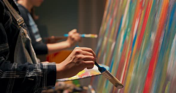 Side View of Two Woman Developing Passion Together Painting an Abstract Picture in Their Hands