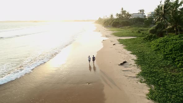 Couple Walking On Sunset Tropical Beach