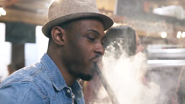 African Young Man Smoking Hookah in the Bar