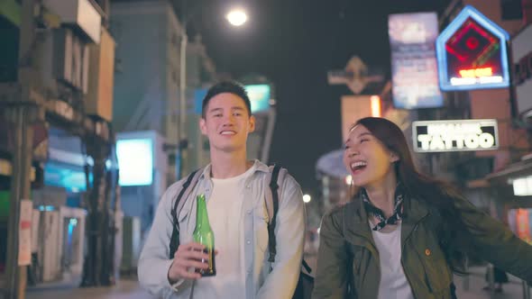 Asian attractive couple drinking alcohol and having party together at dark night on the road.