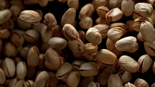 Super Slow Motion Shot of Pistachios Flies After Being Exploded Against Black Background 1000Fps