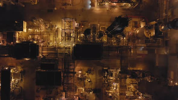 Aerial Topdown Footage Over the Territory of Modern Petroleum Refinery at Night. alt