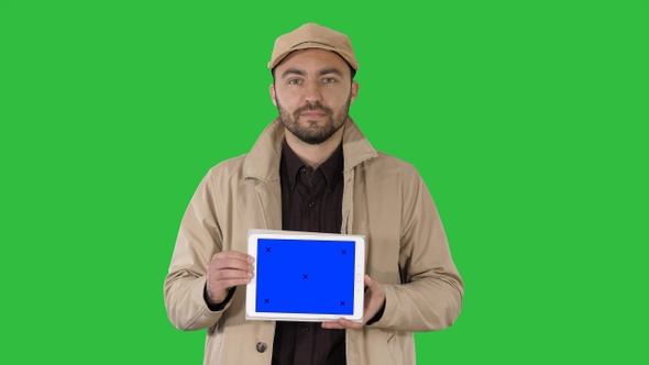Man walking and holding tablet with blue screen mockup