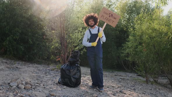 Portrait of Multiracial Guy Eco Volunteer Looking To Camera While Holding Carton Placard with Save