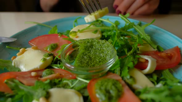 female eating salad sitting in cafe in city