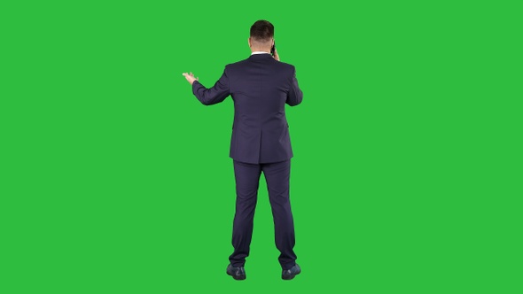 Businessman with smartphone making a phone call on a Green