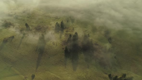 Drone flying sideways over misty landscape. Aerial