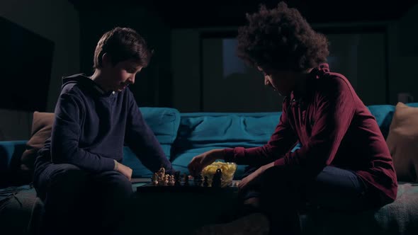 Diverse Teen Boys Moving Pieces on Chess Board