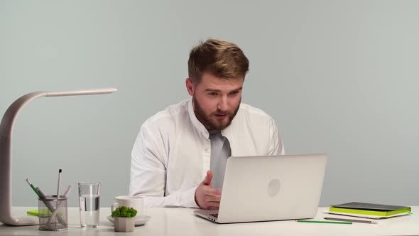 Male Freelancer Has a Video Call with a Client Looking at a Laptop Screen and Discussing a New