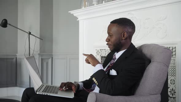 in Private Office Black Businessman Works on a Laptop