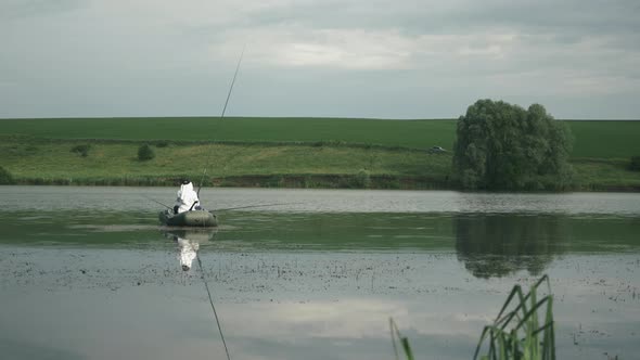 Man in boat fishing with fishing rod. Fisherman catches fish on lake. Fishing on lake.