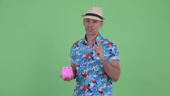Happy Multi Ethnic Tourist Man Holding Piggy Bank and Giving Thumbs Up