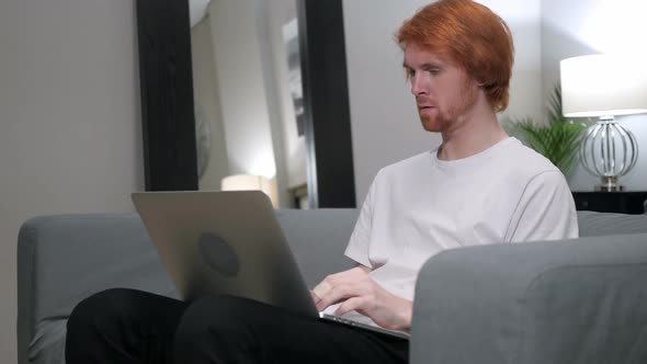 Redhead Man Sad for Failure Working on Laptop