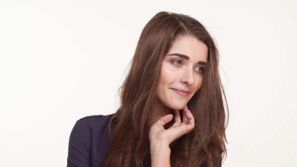 Shy Coy Beautiful Caucasian Female with Long Brown Hair Standing on White Background in Dark Blue