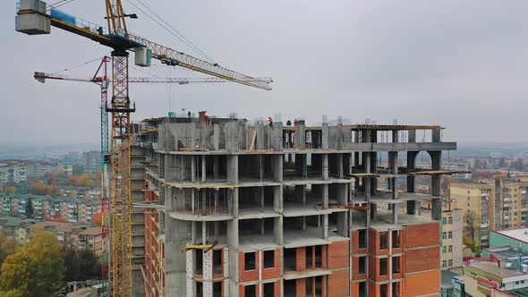 New construction site in the city. Two big cranes constructing the urban building.