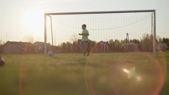 Dad with a Son Playing Football on the Grass