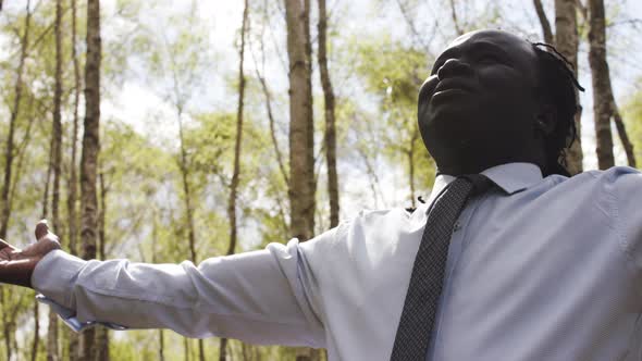 Black Lives Metters. African Businessman with Outstretche Hands Praying in the Park