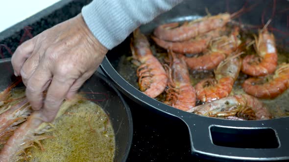 Cook introducing shrimp in a pan with olive oil