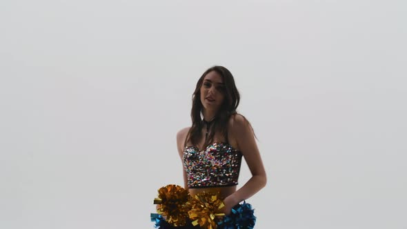 Silhouette of Slender Cheerleader in Shiny Top and Leggings Dancing Energetically with Pompoms in