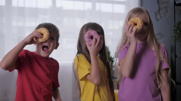 Happy Childhood, Carefree Children Look with One Eye Through Donut During Joint Celebration, Kids