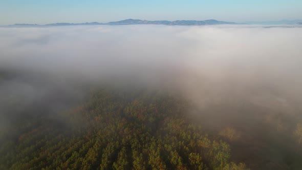 4K Aerial view over high mountain farmland with foggy morning